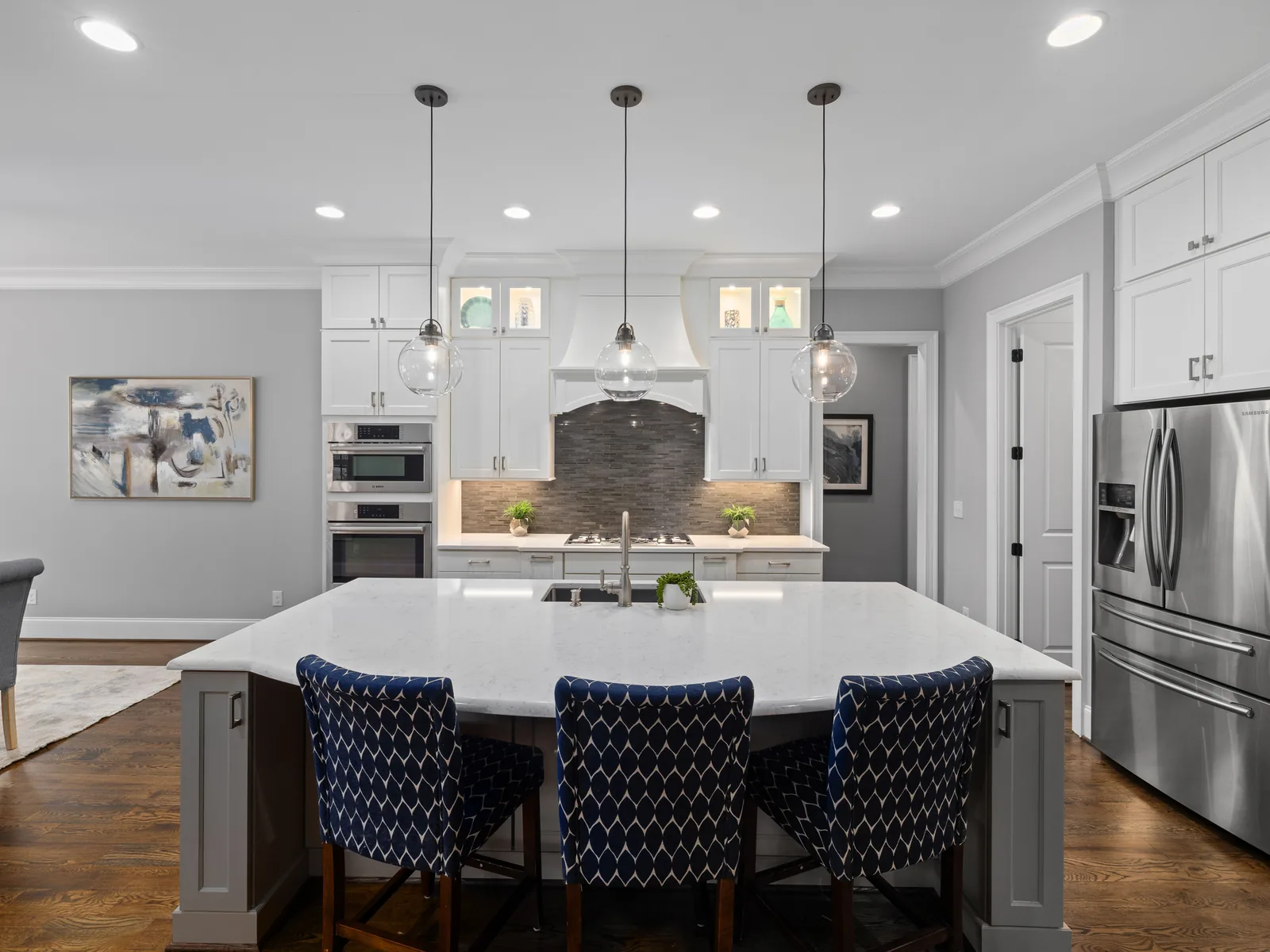 Large kitchen island with navy stools and white countertops
